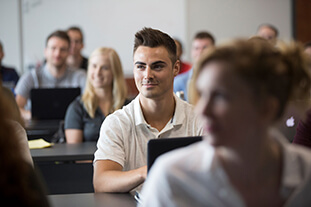 Students sitting at a computer.