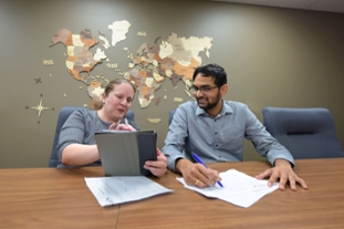 A supervisor showing a co-op students something on a computer.