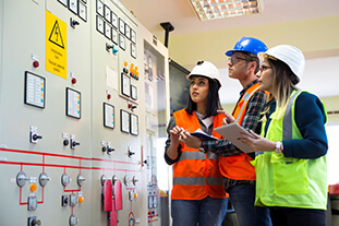 Two students and a supervisor on a work site.