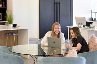 Students sitting at a computer in an office.
